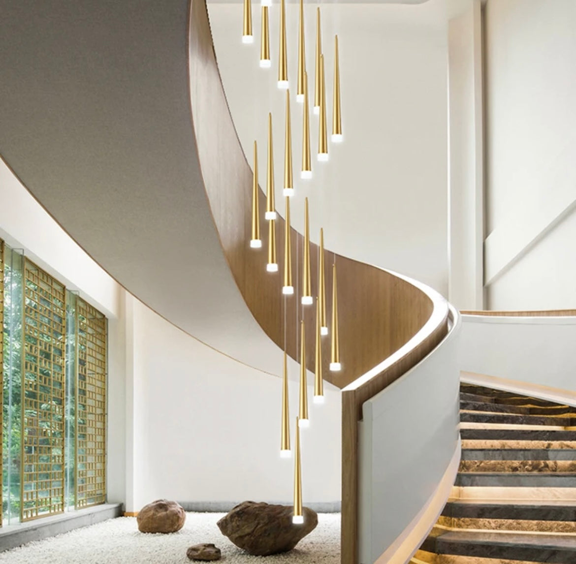 luxury gold tapered chandelier hanging above stairs