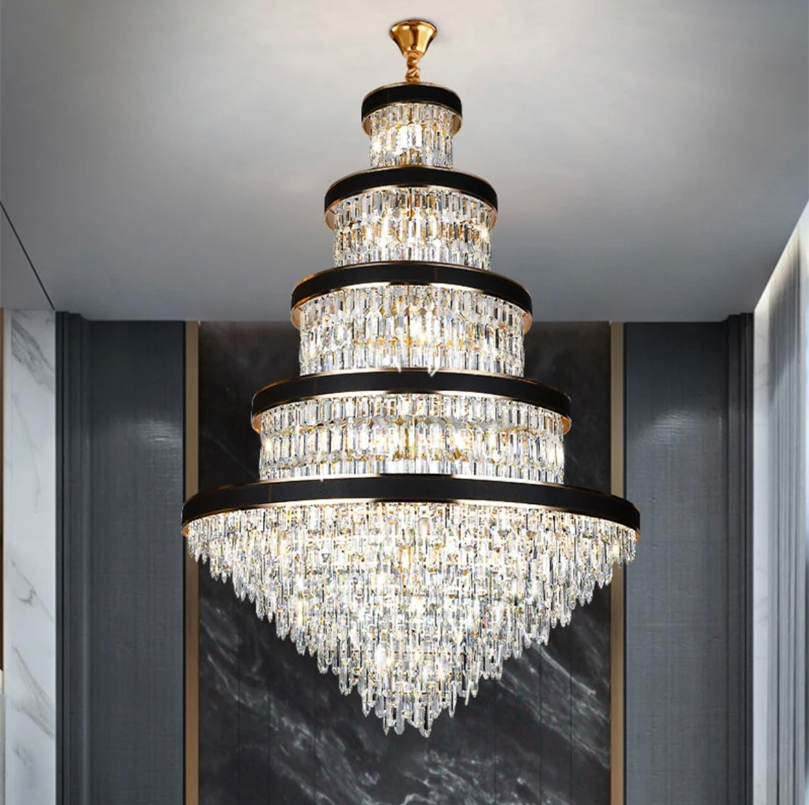 Modern black ring crystal chandelier illuminating a grand staircase