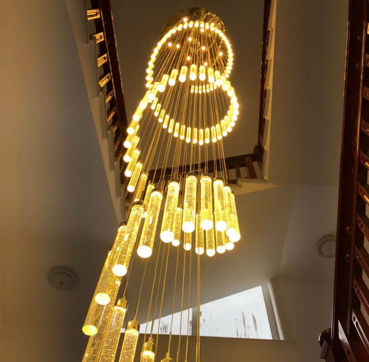 Modern LED long staircase chandelier with cascading effect.