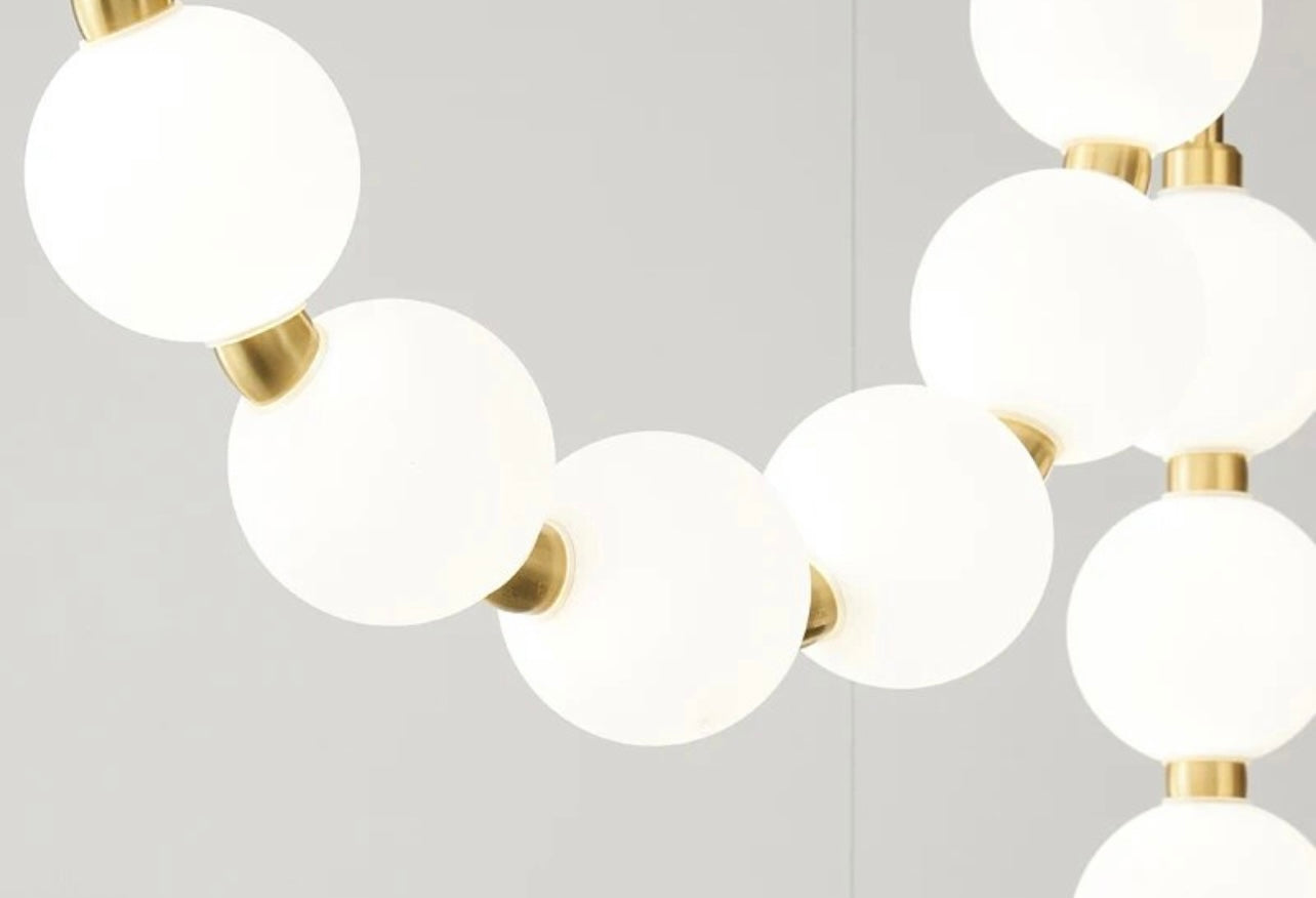 Statement staircase pendant lighting with cascading frosted globes  